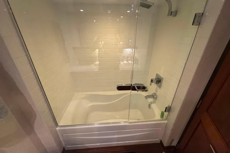 Elsewhere Yacht Photos Pics Luxurious bathroom with glass shower and tub on 2013 Hatteras 60 Motor Yacht.