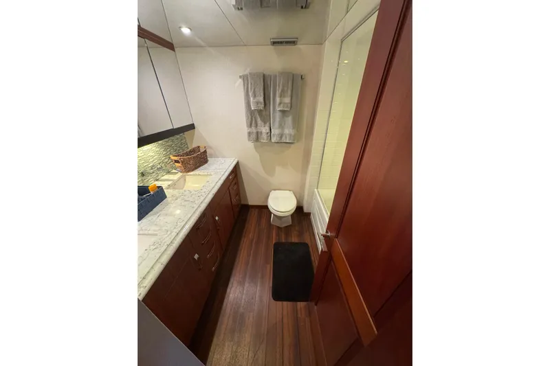 Elsewhere Yacht Photos Pics Bathroom interior of 2013 Hatteras 60 Motor Yacht with wood flooring and marble countertop.
