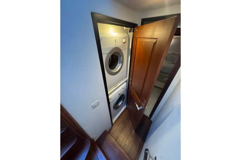 Elsewhere Yacht Photos Pics Laundry area with stacked washer and dryer on 2013 Hatteras 60 Motor Yacht.