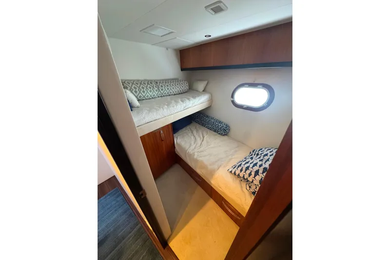 Elsewhere Yacht Photos Pics Bunk beds in 2013 Hatteras 60 Motor Yacht cabin with porthole and cushions.