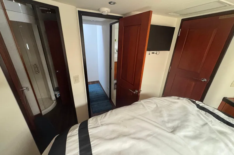 Elsewhere Yacht Photos Pics Interior of 2013 Hatteras 60 Motor Yacht bedroom with ensuite bathroom and TV.