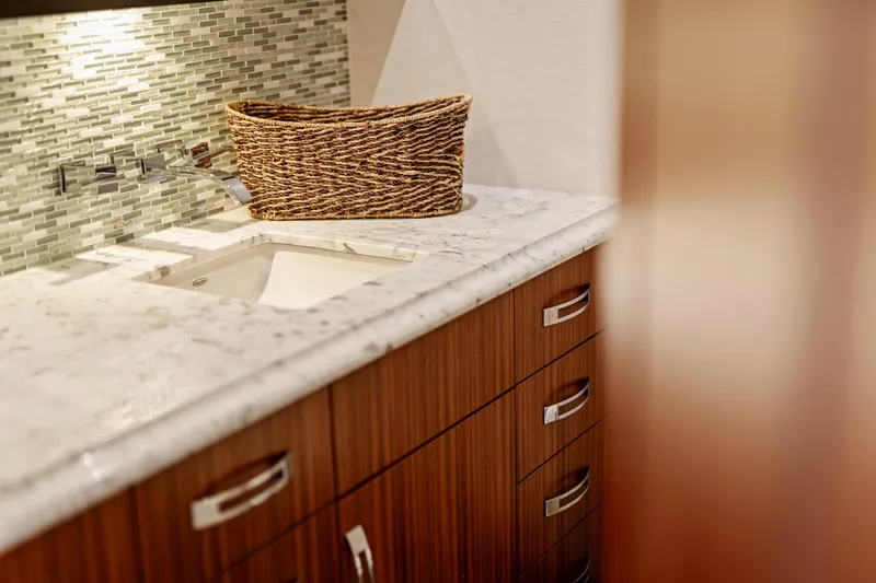 Elsewhere Yacht Photos Pics Luxurious bathroom interior on 2013 Hatteras 60 Motor Yacht with marble countertop and wicker basket.