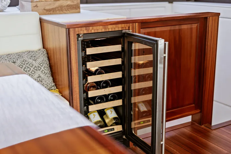 Elsewhere Yacht Photos Pics Wine cooler in 2013 Hatteras 60 Motor Yacht interior, featuring wooden cabinetry and modern design.
