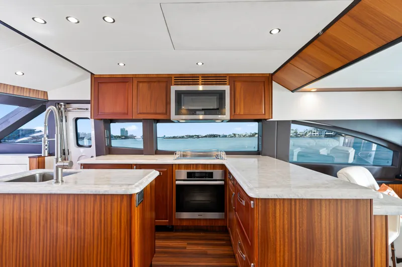 Elsewhere Yacht Photos Pics Luxurious kitchen interior of 2013 Hatteras 60 Motor Yacht with modern appliances and wood finish.