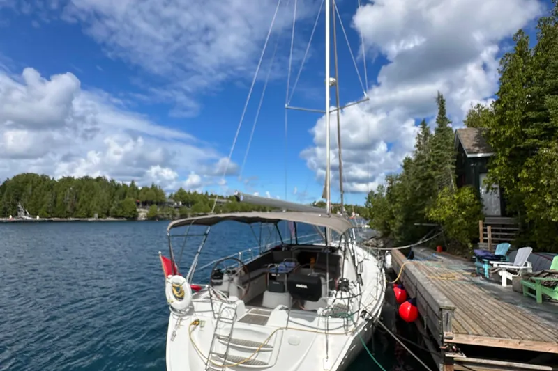 Porte Du Soleil Yacht Photos Pics Jeanneau Sun Odyssey 50 DS 2015 docked by a scenic lakeside with lush greenery.