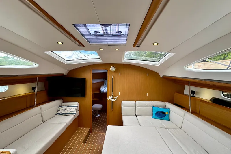 Porte Du Soleil Yacht Photos Pics Luxurious interior of 2015 Jeanneau Sun Odyssey 50 DS sailboat with modern seating and skylights.