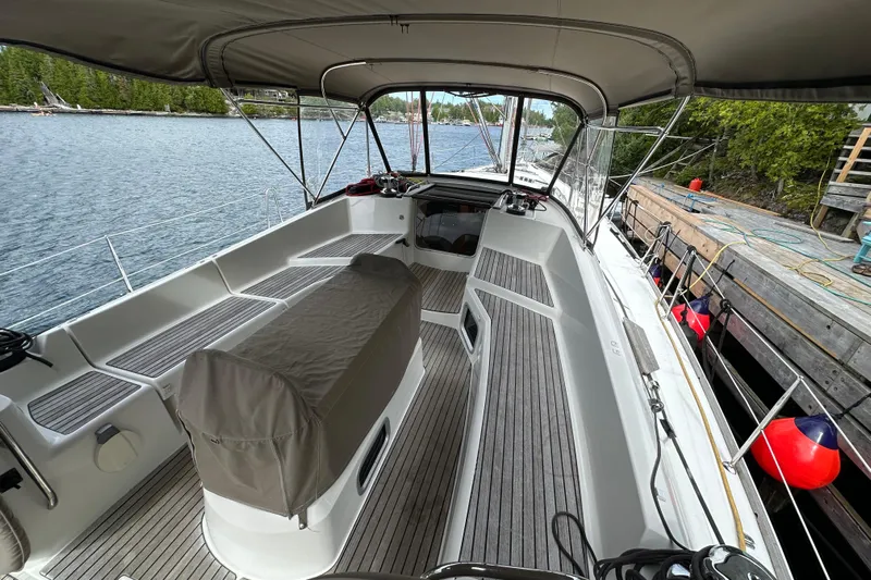 Porte Du Soleil Yacht Photos Pics Spacious cockpit of 2015 Jeanneau Sun Odyssey 50 DS sailboat docked by a serene lake.