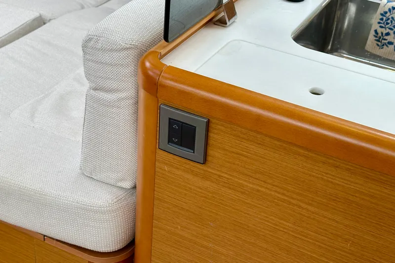 Porte Du Soleil Yacht Photos Pics Interior of 2015 Jeanneau Sun Odyssey 50 DS yacht, featuring wood finish and control panel.