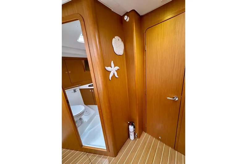 Porte Du Soleil Yacht Photos Pics Interior of 2015 Jeanneau Sun Odyssey 50 DS yacht, featuring wooden paneling and bathroom.