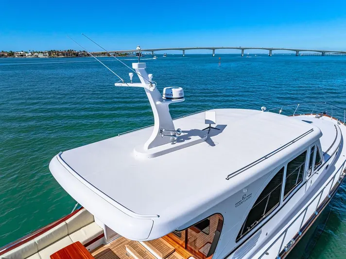 Island Girl III Yacht Photos Pics 2024 Vicem 62 Classic yacht on serene water with bridge in background.