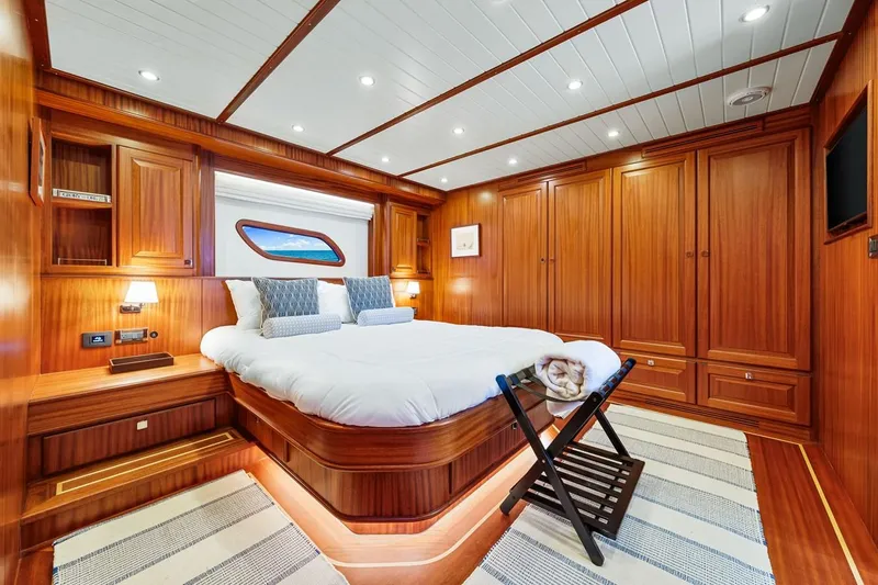 Island Girl III Yacht Photos Pics Luxurious 2024 Vicem 62 Classic yacht cabin with elegant wood paneling and cozy bedding.