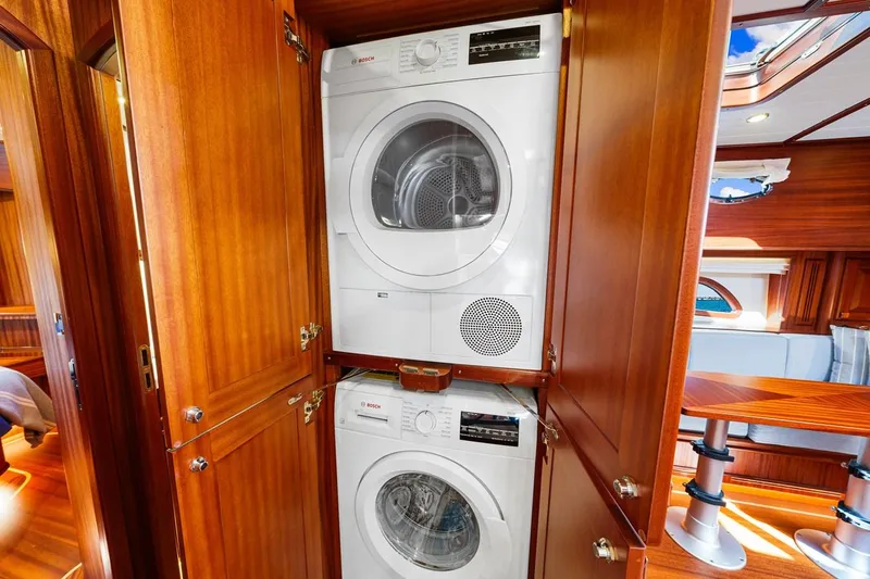 Island Girl III Yacht Photos Pics 2024 Vicem 62 Classic yacht interior with stacked washer and dryer in wooden cabinet.