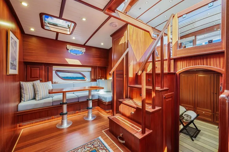 Island Girl III Yacht Photos Pics Luxurious interior of 2024 Vicem 62 Classic yacht with elegant wood finish and cozy seating area.