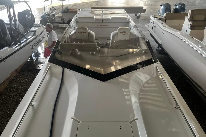  Yacht Photos Pics 2009 Fountain 42 Executioner speedboat in storage, sleek design, white exterior, indoor setting.