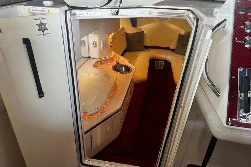  Yacht Photos Pics Interior of a 2009 Fountain 42 Executioner boat, featuring a cozy cabin with seating and kitchenette.