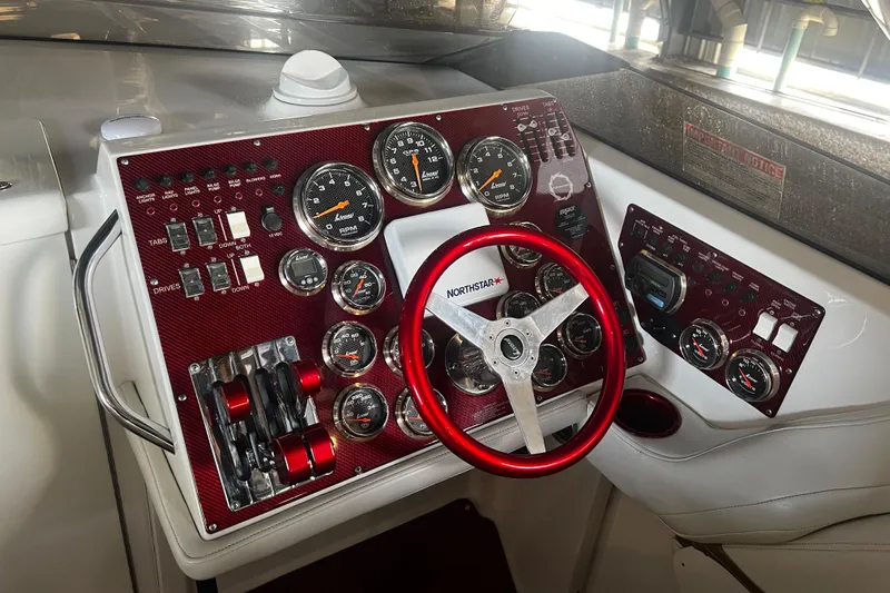  Yacht Photos Pics Control panel of a 2009 Fountain 42 Executioner boat with red steering wheel and gauges.