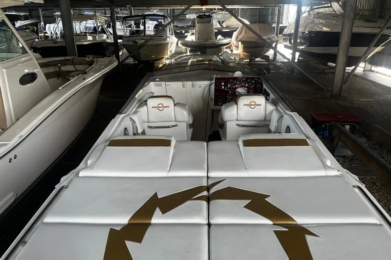  Yacht Photos Pics 2009 Fountain 42 Executioner speedboat in marina, featuring sleek white and gold interior design.