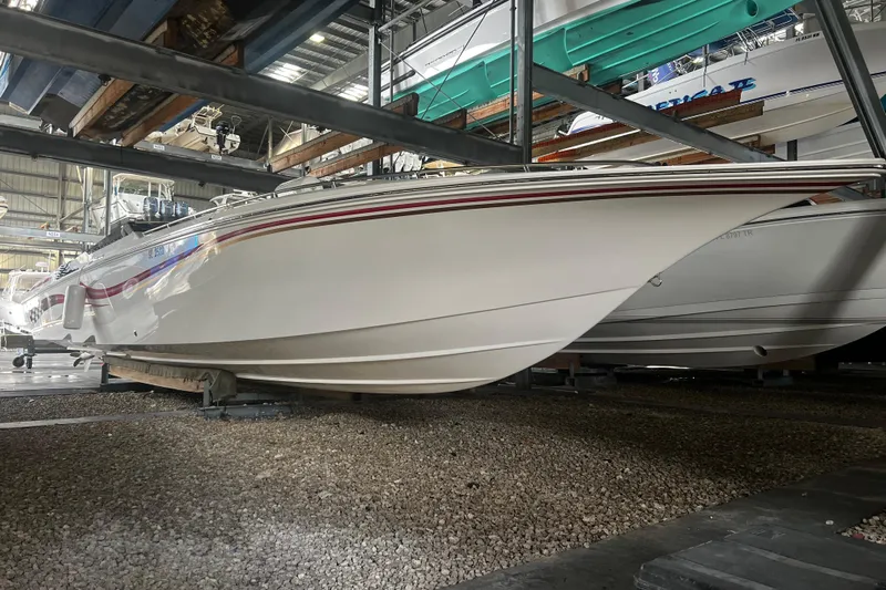  Yacht Photos Pics 2009 Fountain 42 Executioner boat stored indoors on gravel surface.