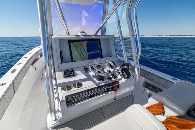  Yacht Photos Pics 2026 SeaVee 320B boat console with navigation screen and steering wheel on open water.