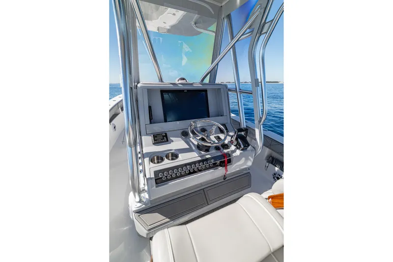  Yacht Photos Pics 2026 SeaVee 320B boat console with steering wheel and navigation screen on open water.