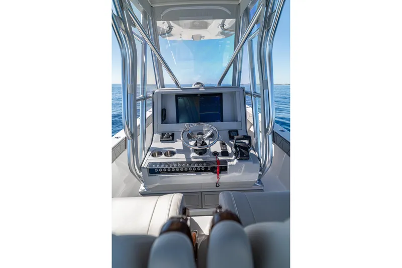  Yacht Photos Pics 2026 SeaVee 320B boat console with steering wheel and navigation screen on open water.