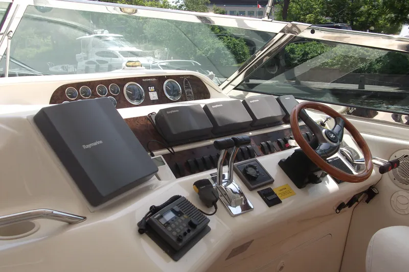  Yacht Photos Pics 1997 Sea Ray 450 Sundancer helm with navigation equipment and wooden steering wheel.