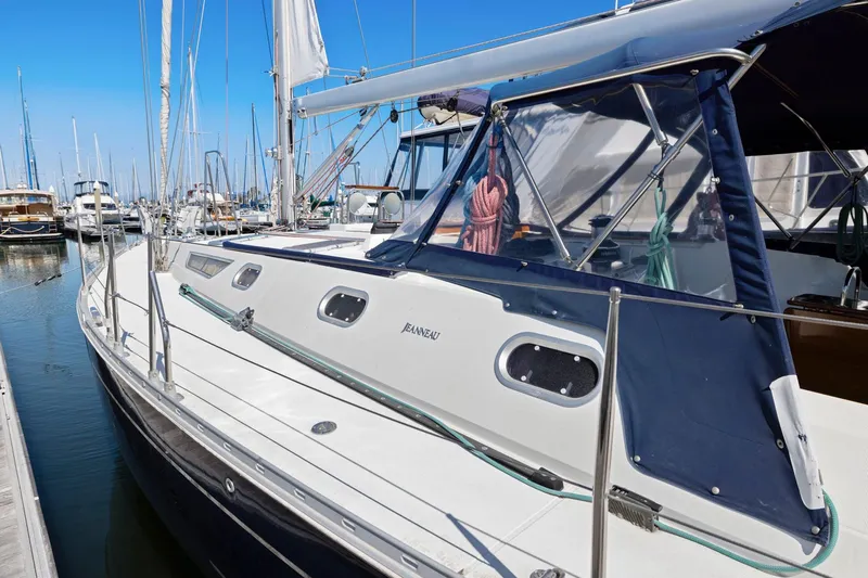 Crazy Horse Yacht Photos Pics Jeanneau Sun Odyssey 52.2 sailboat docked in marina, 2001 model, blue canopy.