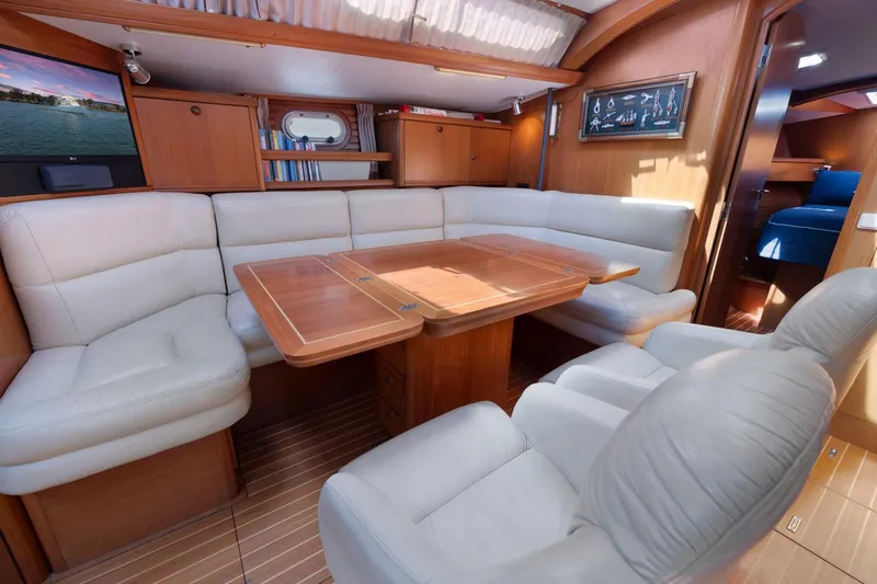 Crazy Horse Yacht Photos Pics Luxurious interior of 2001 Jeanneau Sun Odyssey 52.2 yacht with plush seating and wooden table.
