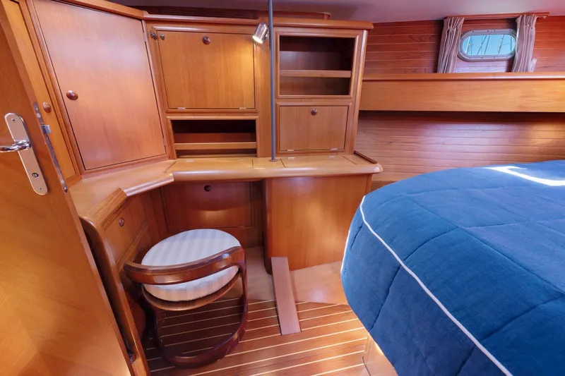 Crazy Horse Yacht Photos Pics Cozy cabin interior of 2001 Jeanneau Sun Odyssey 52.2 with wooden furnishings and blue bedding.