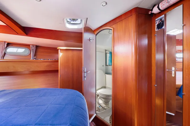 Crazy Horse Yacht Photos Pics Luxurious cabin interior of 2001 Jeanneau Sun Odyssey 52.2 yacht with wooden finish and ensuite bathroom.