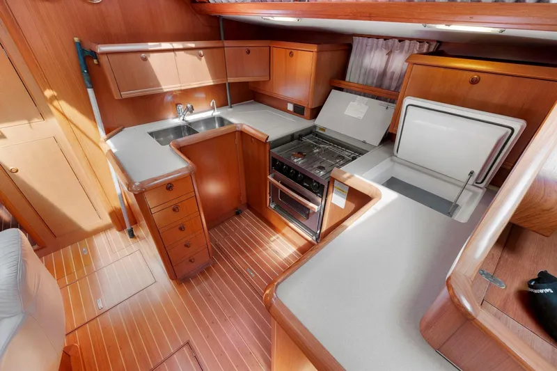 Crazy Horse Yacht Photos Pics Interior of 2001 Jeanneau Sun Odyssey 52.2 yacht kitchen with wood cabinetry and appliances.