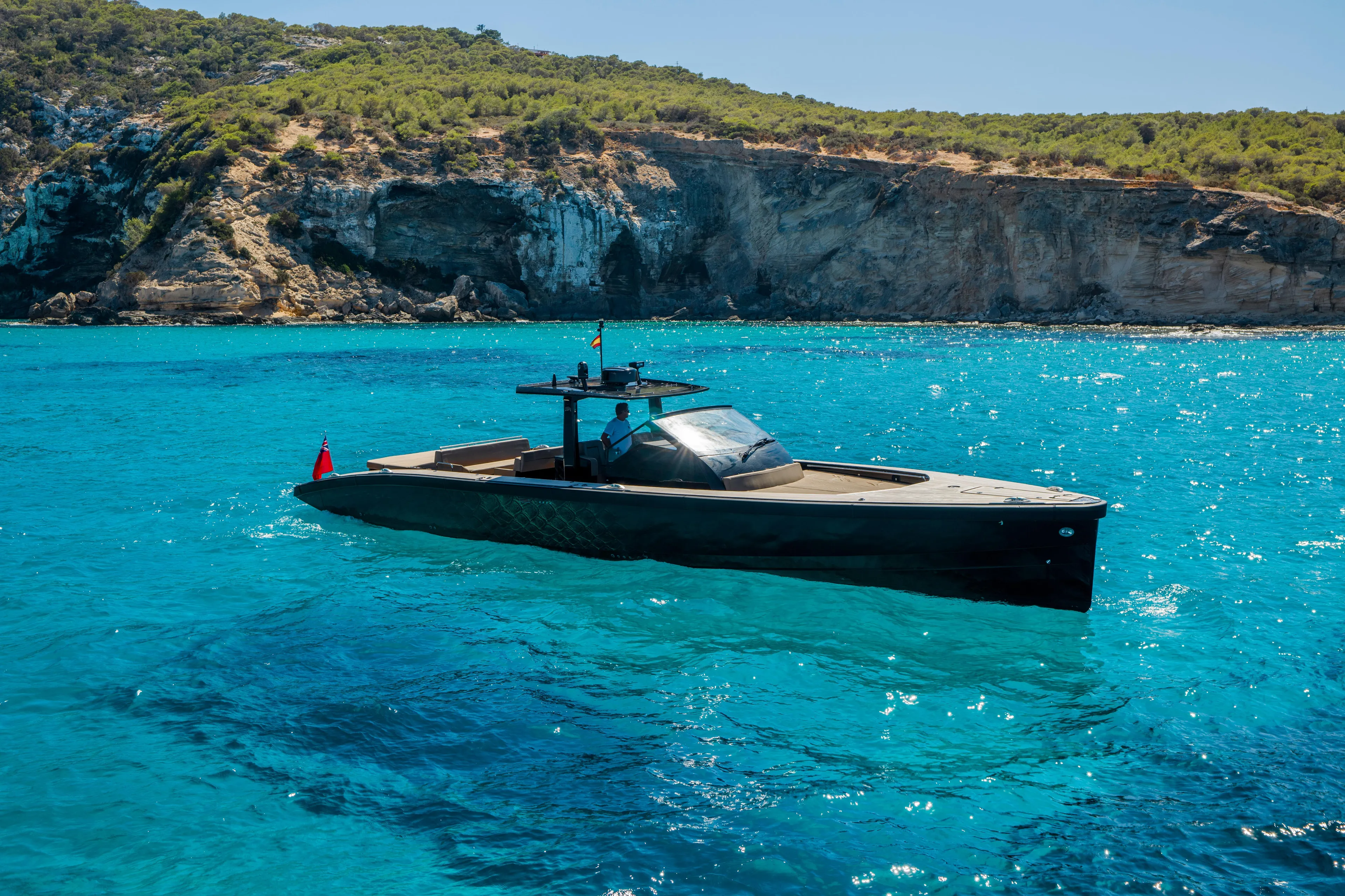 Dragon Yacht Photos Pics 2017 Windy SR52 Blackbird yacht cruising in clear blue waters near rocky coastline.
