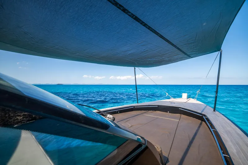 Dragon Yacht Photos Pics 2017 Windy SR52 Blackbird yacht cruising on clear blue ocean under a sunshade.