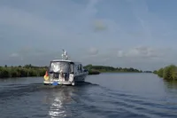 2022 Nimbus 405 Coupé cruising on a serene river under a clear blue sky.