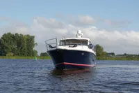 2022 Nimbus 405 Coupé yacht cruising on a serene lake under a clear sky.
