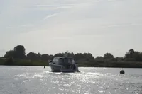 Nimbus 405 Coupé 2022 cruising on a serene, sunlit river.