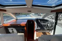 Interior of 2022 Nimbus 405 Coupé yacht with modern helm and panoramic windows.