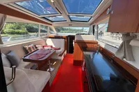 Luxurious interior of 2022 Nimbus 405 Coupé yacht with panoramic windows and modern furnishings.