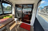 Interior view of 2022 Nimbus 405 Coupé yacht with wooden flooring and seating area.