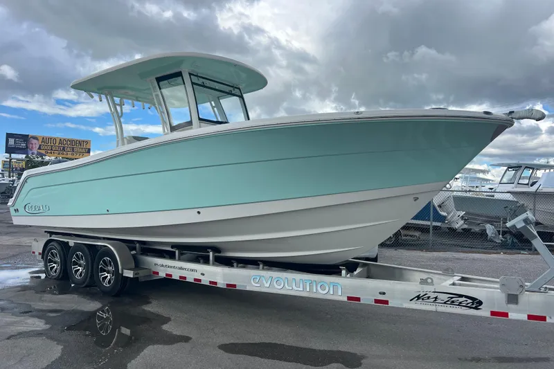  Yacht Photos Pics 2020 Robalo R302 Center Console boat on trailer under cloudy sky.