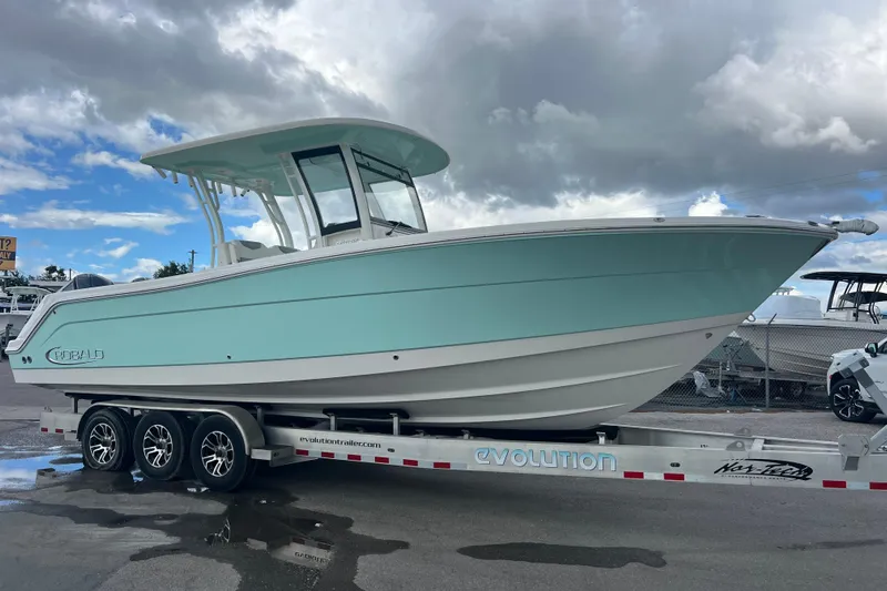  Yacht Photos Pics 2020 Robalo R302 Center Console boat on trailer under cloudy sky.