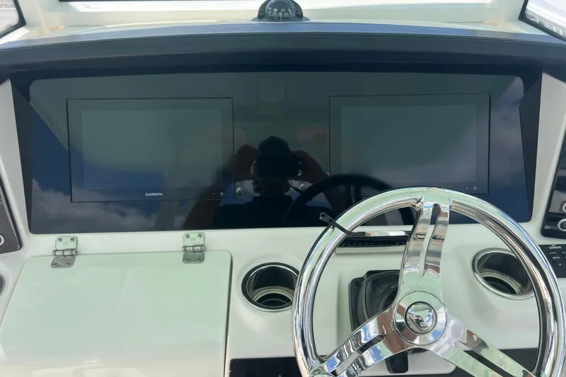  Yacht Photos Pics 2020 Robalo R302 Center Console helm with dual Garmin displays and chrome steering wheel.
