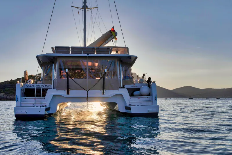 Cabalito De Mar Yacht Photos Pics 2024 Fountaine Pajot Catamaran Elba 45 sailing at sunset on calm waters.