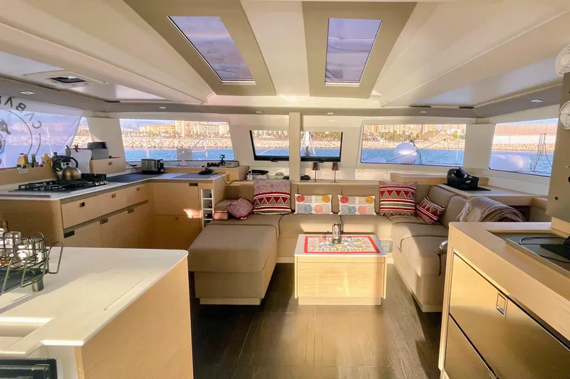 Cabalito De Mar Yacht Photos Pics Luxurious interior of 2024 Fountaine Pajot Catamaran Elba 45 with modern kitchen and seating area.