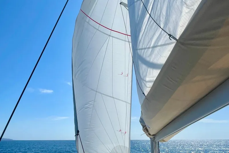 Cabalito De Mar Yacht Photos Pics Sails of 2024 Fountaine Pajot Catamaran Elba 45 against a clear blue sky and ocean.