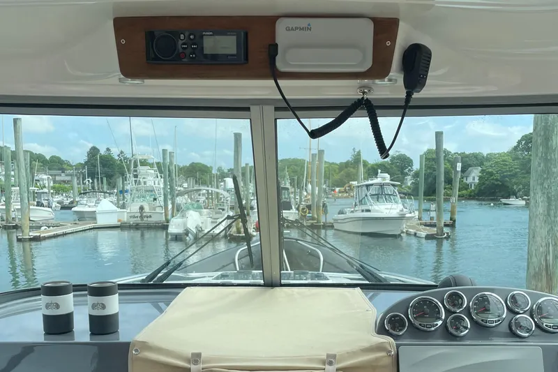  Yacht Photos Pics Interior view of 2018 Protector Tauranga 38 boat at marina, featuring dashboard and controls.