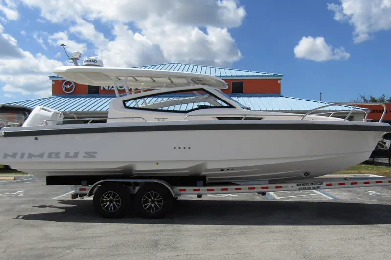  Yacht Photos Pics 2025 Nimbus Weekender 9 boat on trailer, parked outdoors under a cloudy sky.