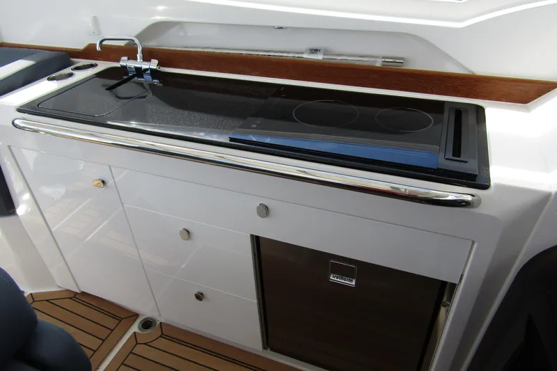  Yacht Photos Pics Modern kitchenette on 2025 Nimbus Weekender 9 boat with stove and sink.