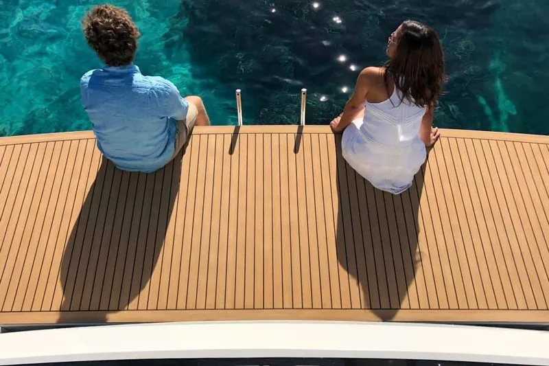  Yacht Photos Pics Couple relaxing on De Antonio Yachts D42, 2026 model, overlooking clear blue water.