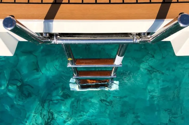  Yacht Photos Pics Stainless steel ladder on De Antonio Yachts D42, 2026 model, above clear turquoise water.